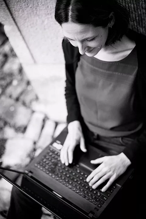 Monika Wels schreibt auf dem Laptop